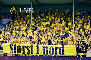 Bodø/Glimts supportere J-feltet holder opp en gul TIFO med teksten "Størst i nord" under slaget om Nord-Norge mellom Bodø/Glimt og Tromsø i cupen 2023.