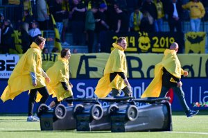 Deltakerne klare til fotballcurling, med en vri, i pausen under kampen mot Strømsgodset på Aspmyra. 