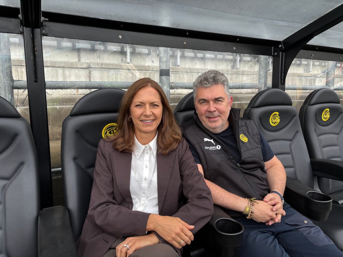 Nina og Frode sitter på Glimt-benken og smiler. 