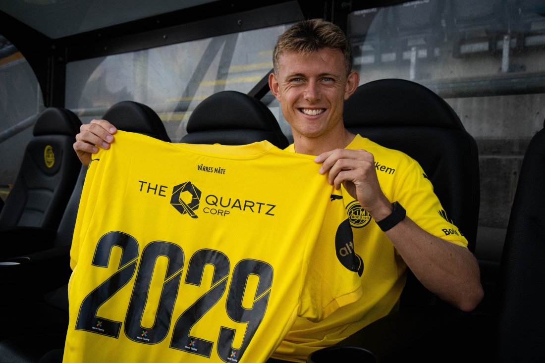 Mathias Jørgensen holder opp en drakt for å vise at han har signert en kontrakt fram til sommeren 2029. 